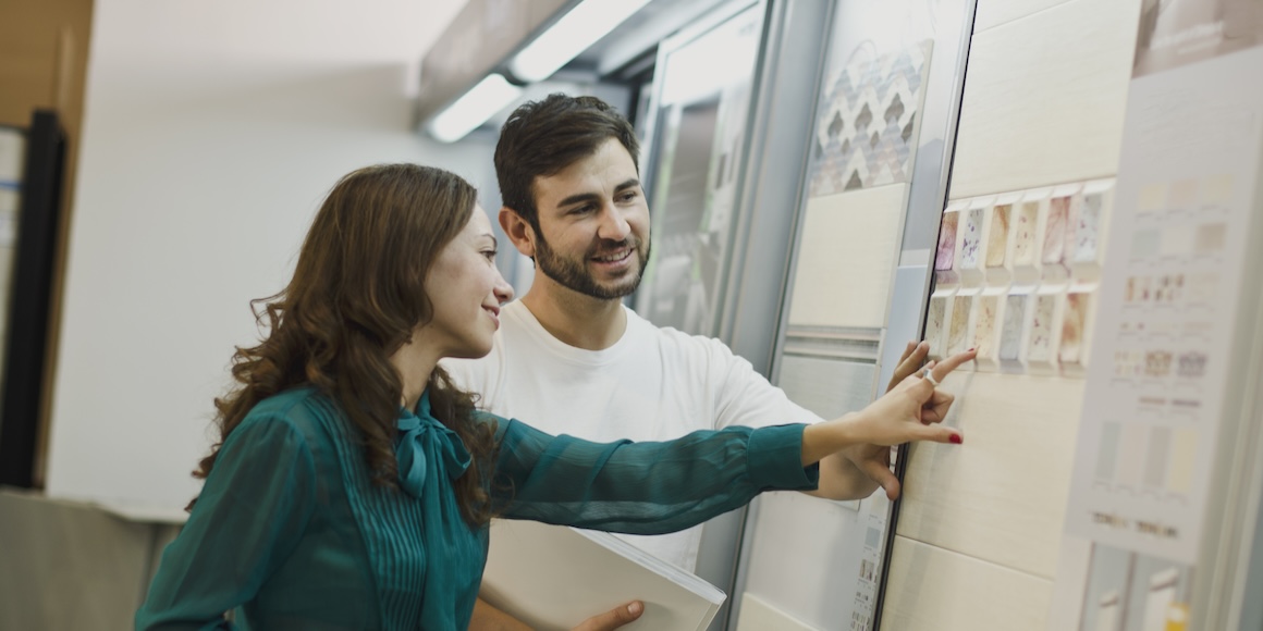 A couple assessing bathroom tiles for a remodel